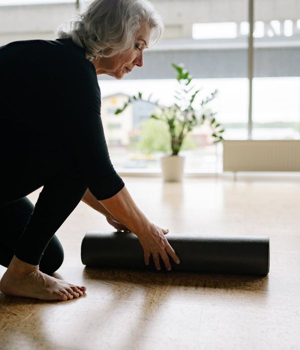 Woman performing a graceful flexibility exercise in a calm setting.